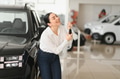 Lady in a car salon. Woman buying the car. In a white shirt - PhotoDune Item for Sale