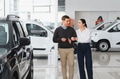 Couple checking new luxury cars at dealership automobile salon - PhotoDune Item for Sale