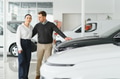 Happy young couple chooses and buying a new car for the family. Visitting the dealership - PhotoDune Item for Sale