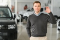 Handsome man customer holding key from auto, buying brand new car in showroom - PhotoDune Item for Sale