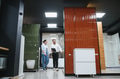 Salesman showing ceramic tiles to woman in bathroom furniture store - PhotoDune Item for Sale