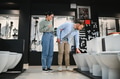 Couple choosing toilet bowl in plumbing store, examining sanitary ware in bathroom showroom - PhotoDune Item for Sale