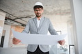 Architect reading blueprint on construction site wearing hardhat - PhotoDune Item for Sale