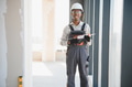 Construction worker holding silicone sealant gun in building under construction - PhotoDune Item for Sale