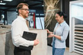 Salesman showing ceramic tile to customer in hardware store - PhotoDune Item for Sale