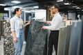 Salesman showing ceramic tile to woman in hardware store - PhotoDune Item for Sale