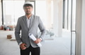 Arab architect holding blueprints supervising construction site project - PhotoDune Item for Sale