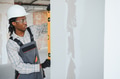 Construction worker checking wall straightness with spirit level - PhotoDune Item for Sale