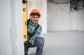 Smiling arab engineer using spirit level on construction site - PhotoDune Item for Sale