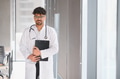Arab male doctor holding medical chart in hospital corridor - PhotoDune Item for Sale