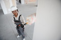 Construction worker painting wall with roller in building under construction - PhotoDune Item for Sale