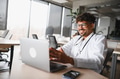 Arab male doctor having video conference on laptop in modern clinic - PhotoDune Item for Sale