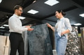 Shop assistant showing ceramic tile to woman in store - PhotoDune Item for Sale