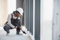 Construction worker sealing window frame in building under construction - PhotoDune Item for Sale