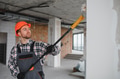 Construction worker painting wall with roller in building under construction - PhotoDune Item for Sale