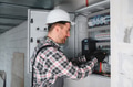 Electrician repairing electrical panel in building under construction - PhotoDune Item for Sale