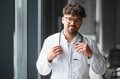 Portrait of confident arab male doctor holding stethoscope in hospital corridor - PhotoDune Item for Sale