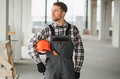 Construction worker holding helmet and planning next steps in building - PhotoDune Item for Sale