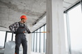 Construction worker painting wall with roller in building under construction - PhotoDune Item for Sale