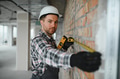 Construction worker measuring brick wall with tape measure and level tool - PhotoDune Item for Sale