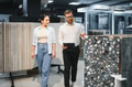Shop assistant showing ceramic tiles to woman in hardware store - PhotoDune Item for Sale