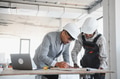 Architect and builder reviewing blueprint on construction site - PhotoDune Item for Sale
