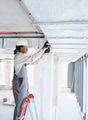 Construction worker installing ventilation system on a ladder in building site - PhotoDune Item for Sale