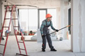 Arab Construction worker painting walls with roller brush on telescopic handle - PhotoDune Item for Sale