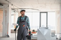 Arab engineer walking in building under construction carrying paint roller and toolbox - PhotoDune Item for Sale