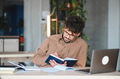 Focused arab student studying and taking notes in university library - PhotoDune Item for Sale