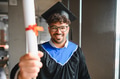 Happy arab student showing university diploma at graduation ceremony - PhotoDune Item for Sale