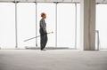 Construction worker walking in building under construction with paint roller - PhotoDune Item for Sale