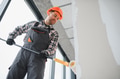 Construction worker painting walls with roller in building renovation - PhotoDune Item for Sale