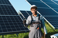 Middle eastern technician installing solar panels on green field - PhotoDune Item for Sale