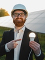 Engineer showing light bulb from solar panel farm, renewable energy for future - PhotoDune Item for Sale