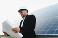 Arab engineer examining blueprint near solar panel installation - PhotoDune Item for Sale