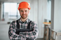Construction worker smiling with arms crossed in building under construction - PhotoDune Item for Sale