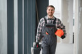 Hvac technician walking in building carrying tools and helmet - PhotoDune Item for Sale