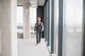 Construction worker walking in unfinished building carrying tools - PhotoDune Item for Sale