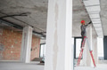 Construction worker installing ventilation system on a ladder in building under construction - PhotoDune Item for Sale