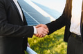 Businessmen shaking hands in front of solar panels, investing in renewable energy - PhotoDune Item for Sale