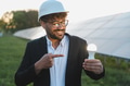 Arab businessman showing lit lightbulb near solar panels - PhotoDune Item for Sale