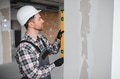 Construction worker using spirit level on wall during renovation - PhotoDune Item for Sale