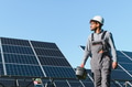 Engineer walking in solar panel farm carrying toolbox on sunny day - PhotoDune Item for Sale