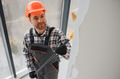 Construction worker painting wall with roller in building under construction - PhotoDune Item for Sale