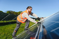 Technician installing solar panels in a solar farm generating green energy - PhotoDune Item for Sale