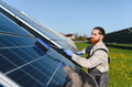 Technician cleaning solar panels in a solar farm for green energy production - PhotoDune Item for Sale