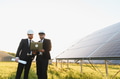 Engineers using laptop analyzing solar panel farm investment - PhotoDune Item for Sale