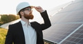 Investor wearing hardhat inspecting solar panel farm at sunset - PhotoDune Item for Sale