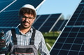 Engineer holding drill installing solar panels in solar farm - PhotoDune Item for Sale